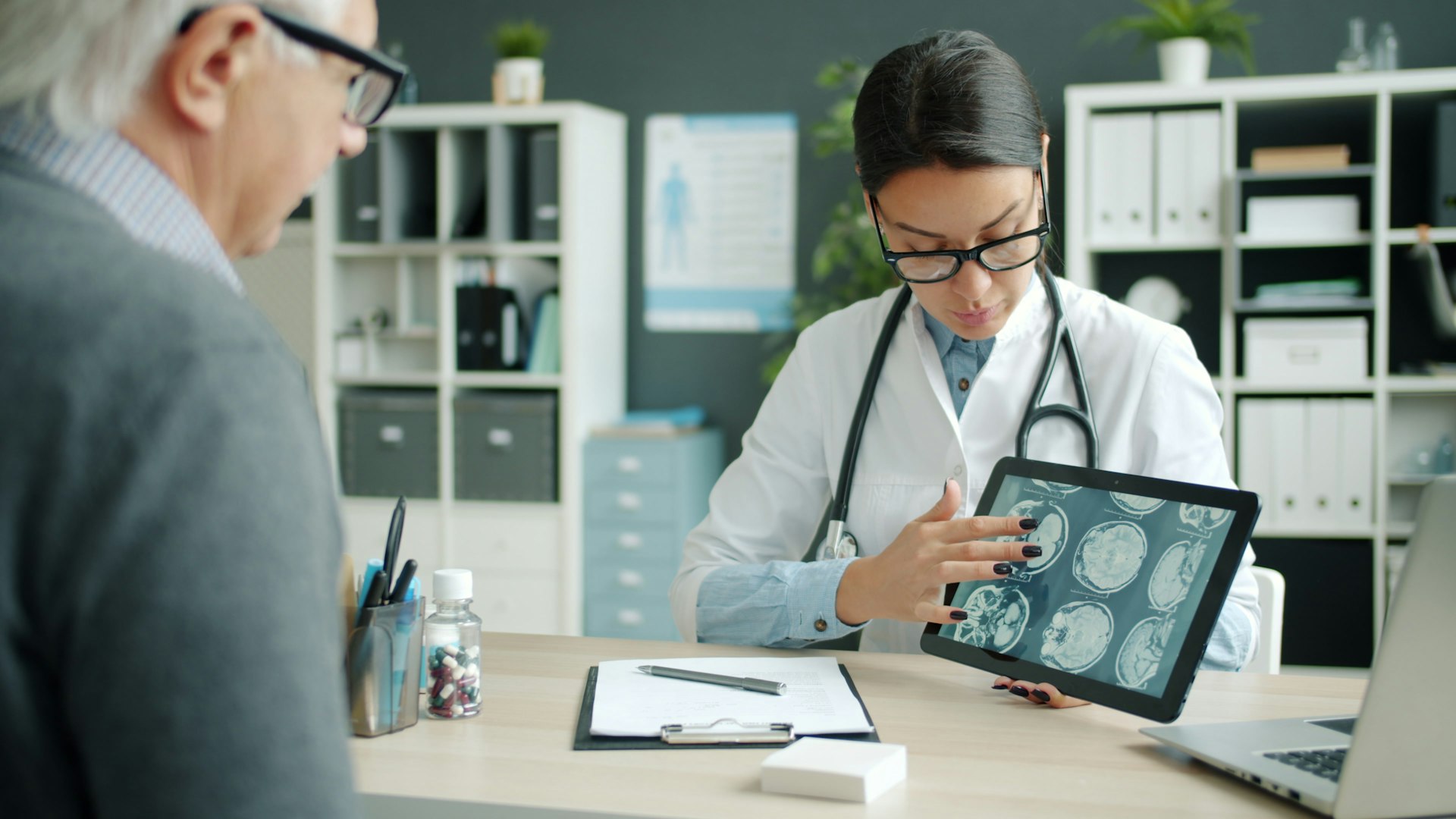 A doctor reviewing digital medical scans with a patient on a tablet